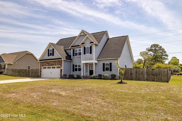 craftsman inspired home with fence, a shingled roof, a front yard, and concrete driveway
