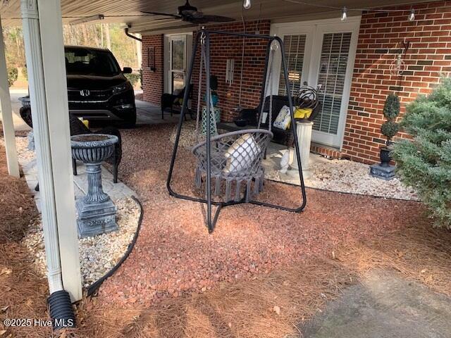 view of patio / terrace with ceiling fan and a carport