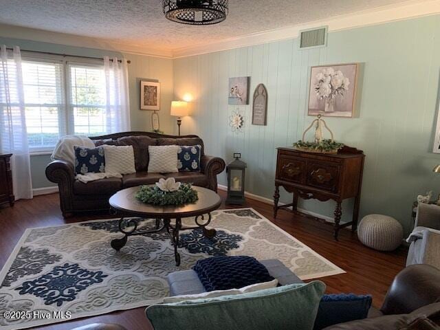 living room with crown molding, dark hardwood / wood-style floors, and a textured ceiling