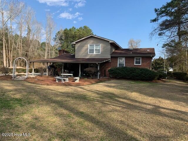 rear view of house featuring a lawn