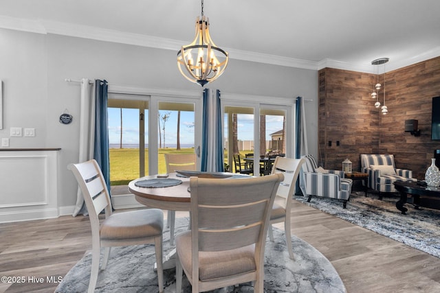 dining area with crown molding, baseboards, wood finished floors, and an inviting chandelier