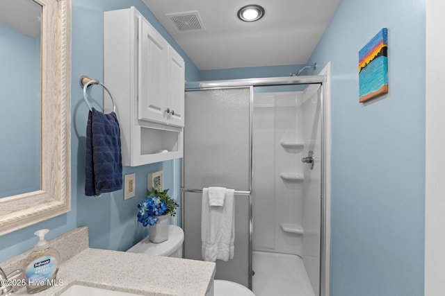 full bathroom featuring a stall shower, visible vents, vanity, and toilet