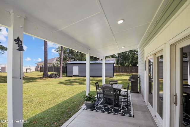 view of patio with outdoor dining area, grilling area, a shed, a fenced backyard, and an outdoor structure