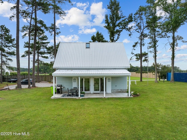 rear view of house with a lawn, a patio, and fence