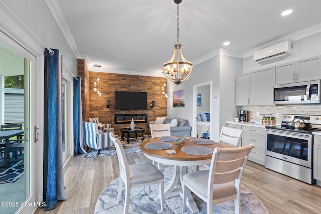 dining space with a chandelier, ornamental molding, light wood finished floors, and a wall mounted air conditioner