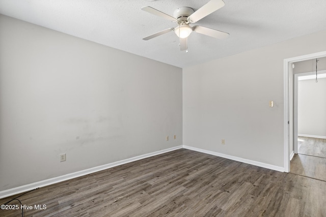 empty room featuring baseboards, ceiling fan, and wood finished floors