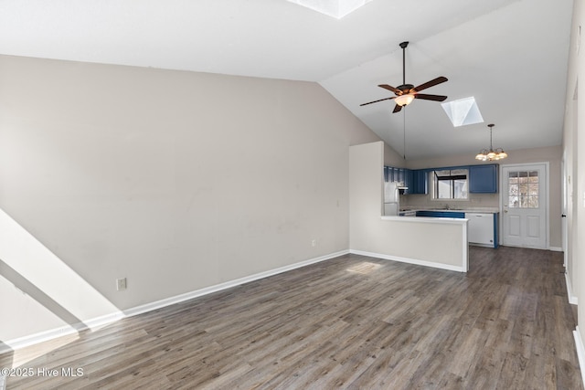 unfurnished living room featuring wood finished floors, vaulted ceiling with skylight, ceiling fan with notable chandelier, and baseboards