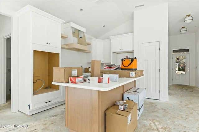 kitchen featuring white cabinets, a center island, lofted ceiling, and a kitchen breakfast bar