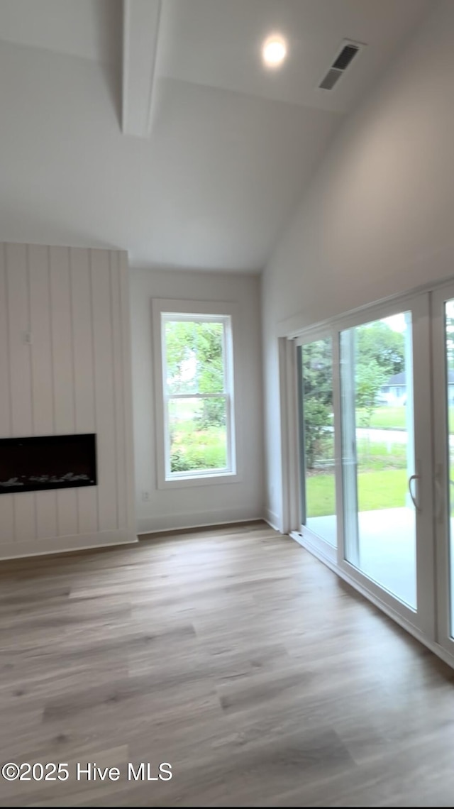 1643 Deerfield Dr SW, Ocean Isle Beach, NC 28469 - unfurnished living room with wood finished floors, a fireplace, high vaulted ceiling, and beamed ceiling
