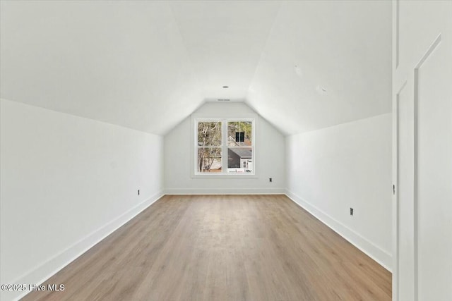 additional living space featuring light hardwood / wood-style floors and lofted ceiling