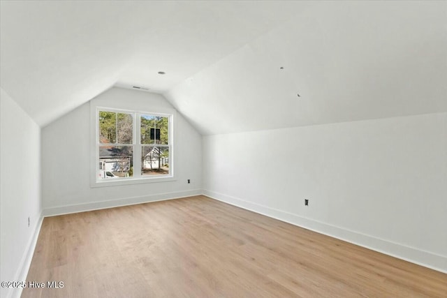 additional living space with lofted ceiling and light hardwood / wood-style flooring