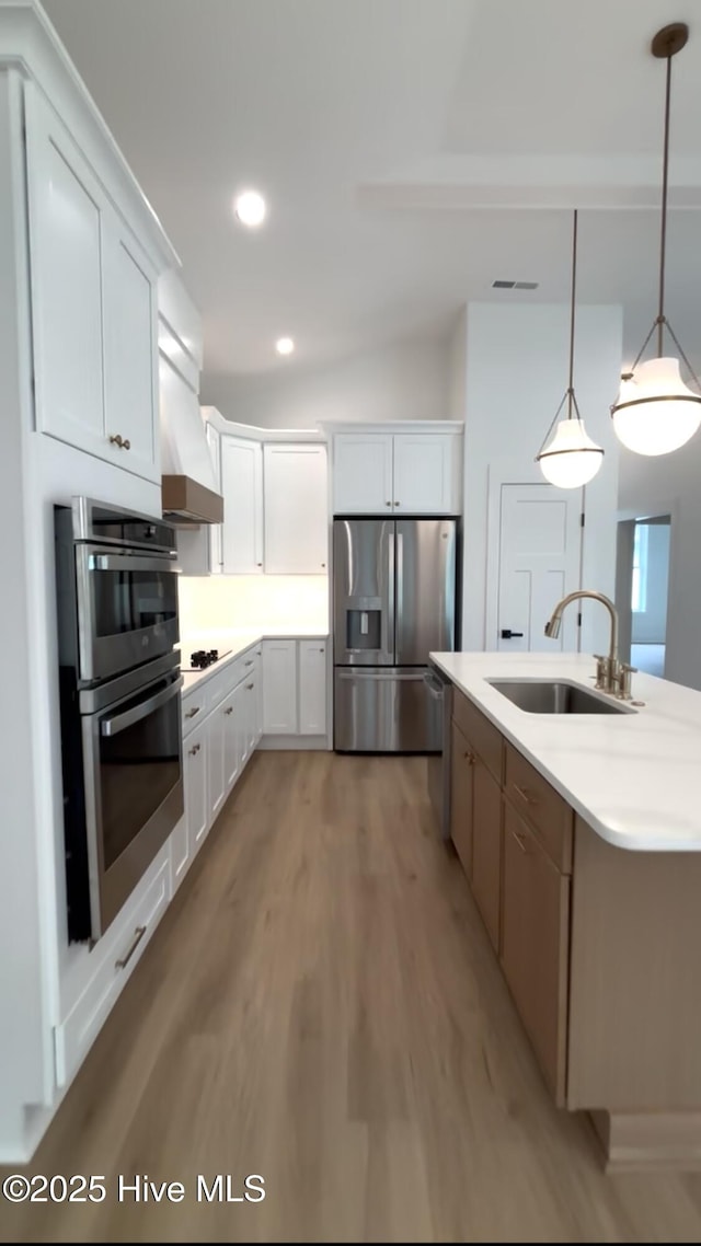 1643 Deerfield Dr SW, Ocean Isle Beach, NC 28469 - kitchen with stainless steel appliances, light wood-style flooring, premium range hood, white cabinets, and recessed lighting
