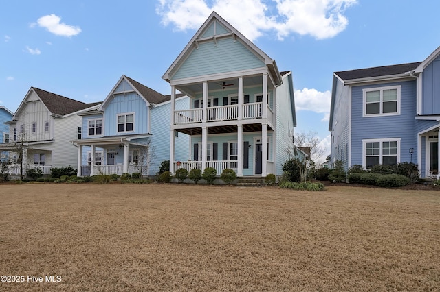 view of front of home featuring ceiling fan, a porch, a balcony, and a front yard