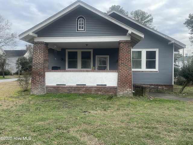 bungalow-style home featuring a porch and a front lawn