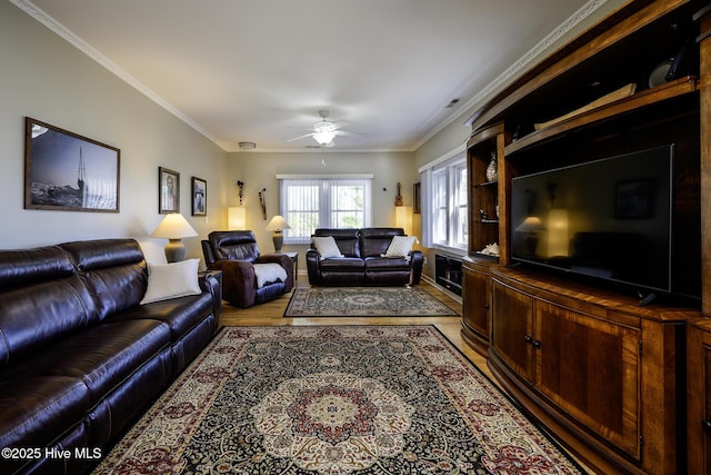 living area featuring light wood-style floors, crown molding, and ceiling fan