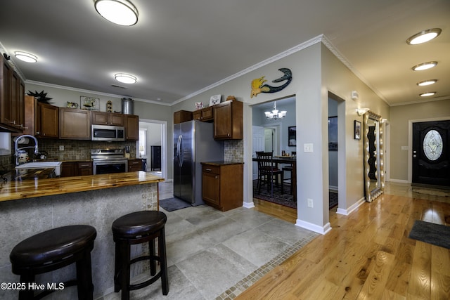 kitchen with dark countertops, tasteful backsplash, appliances with stainless steel finishes, and a sink