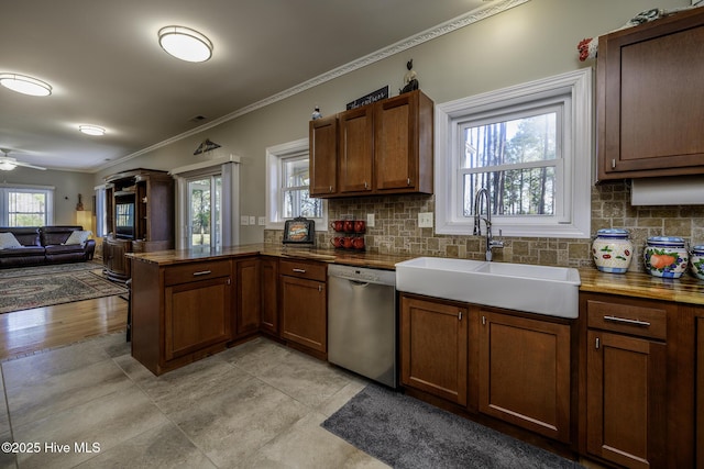 kitchen with a peninsula, a sink, open floor plan, stainless steel dishwasher, and backsplash