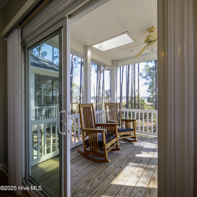 sunroom featuring lofted ceiling with skylight and a ceiling fan