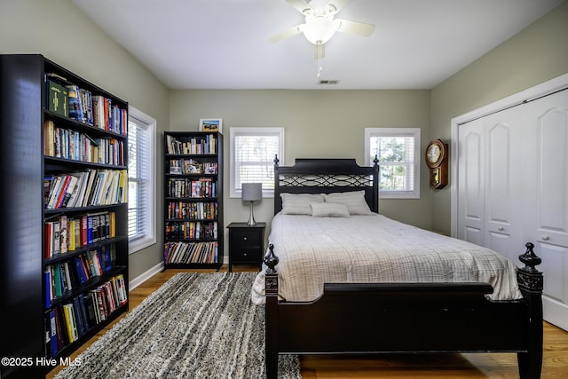 bedroom with a ceiling fan, a closet, baseboards, and wood finished floors