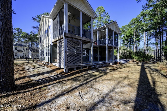 view of side of property featuring a sunroom and ceiling fan