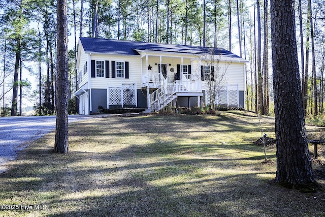 view of front of home featuring a garage, covered porch, driveway, and stairway