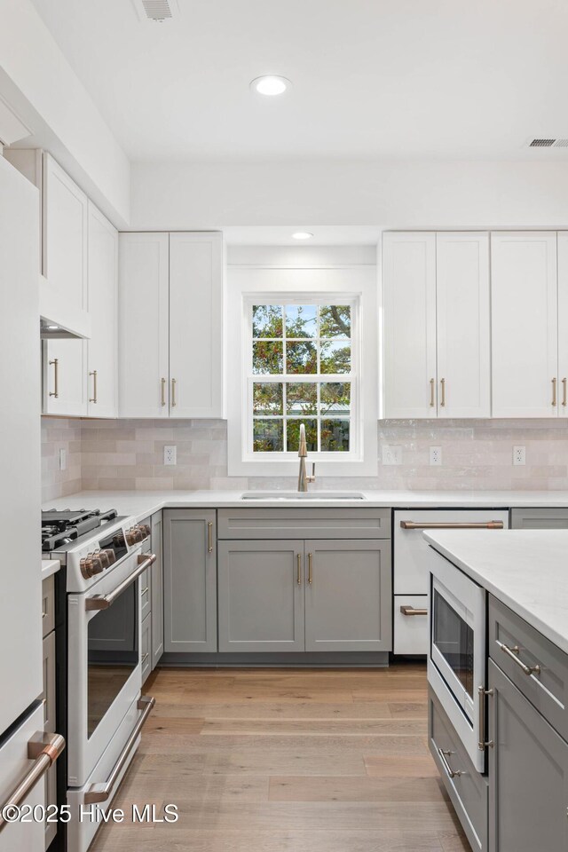 1773 Oakbrook Dr SW, Ocean Isle Beach, NC 28469 - kitchen featuring gray cabinets, a sink, white appliances, and visible vents