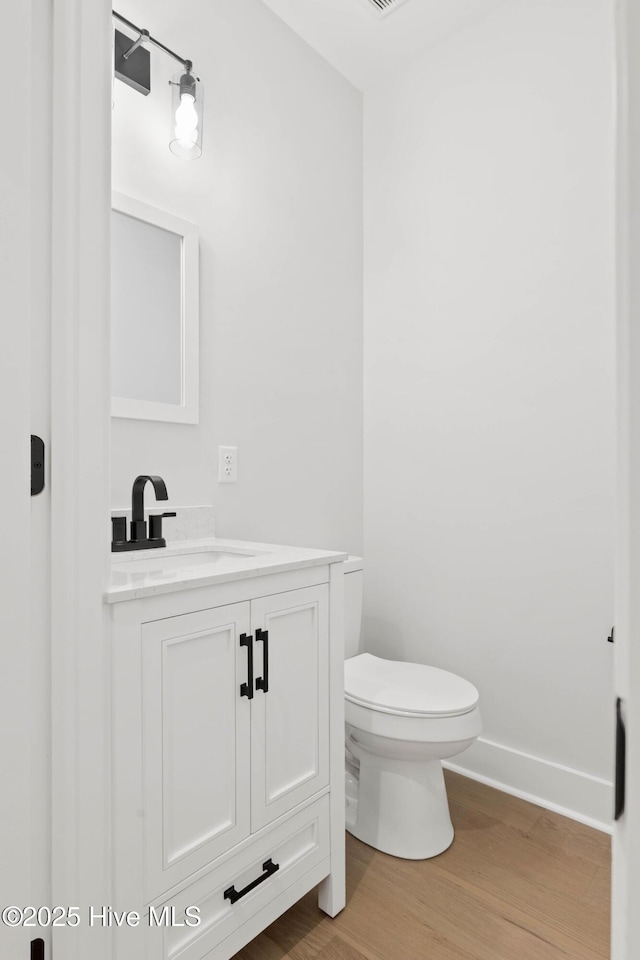 1773 Oakbrook Dr SW, Ocean Isle Beach, NC 28469 - bathroom with toilet, wood finished floors, vanity, and baseboards