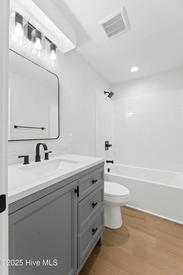 1773 Oakbrook Dr SW, Ocean Isle Beach, NC 28469 - bathroom featuring bathtub / shower combination, vanity, visible vents, toilet, and wood finished floors