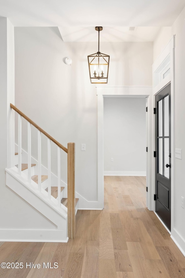 1773 Oakbrook Dr SW, Ocean Isle Beach, NC 28469 - entryway featuring baseboards, stairway, a notable chandelier, and wood finished floors