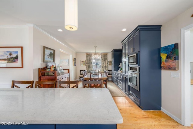 kitchen with light wood-style flooring, blue cabinets, stainless steel appliances, crown molding, and pendant lighting