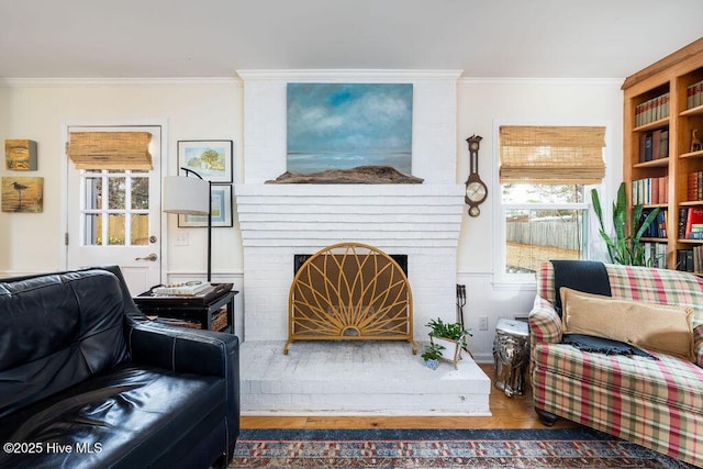 living room featuring a brick fireplace and crown molding