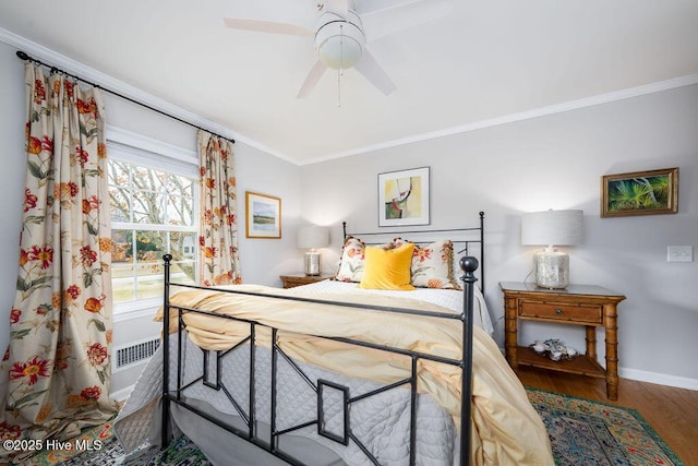 bedroom with ornamental molding, ceiling fan, baseboards, and wood finished floors