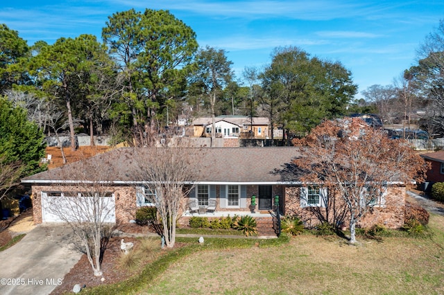 single story home featuring a garage, a shingled roof, concrete driveway, a porch, and a front yard