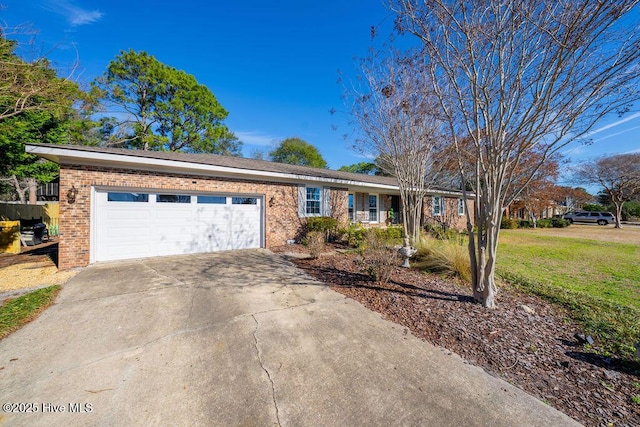 ranch-style house with concrete driveway, brick siding, an attached garage, and a front yard