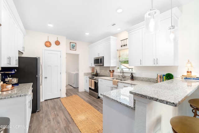 kitchen featuring white cabinetry, stainless steel appliances, a breakfast bar, and kitchen peninsula