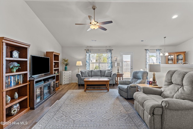 living room with a ceiling fan, vaulted ceiling, and wood finished floors