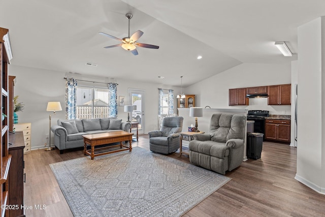 living area featuring ceiling fan, visible vents, wood finished floors, baseboards, and lofted ceiling
