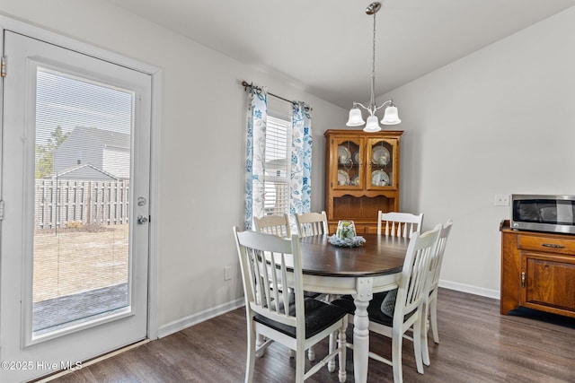 dining space featuring baseboards, vaulted ceiling, and dark wood-style floors