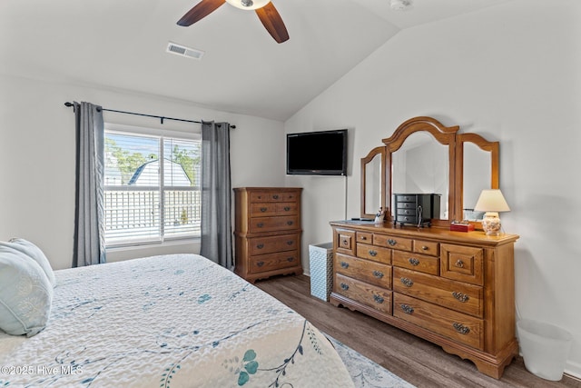 bedroom featuring ceiling fan, vaulted ceiling, wood finished floors, and visible vents