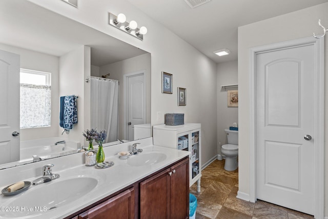full bathroom with double vanity, a sink, baseboards, and toilet