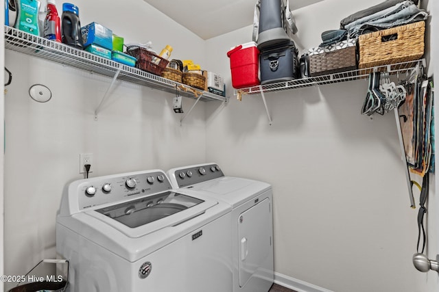 washroom with baseboards, laundry area, and washing machine and dryer