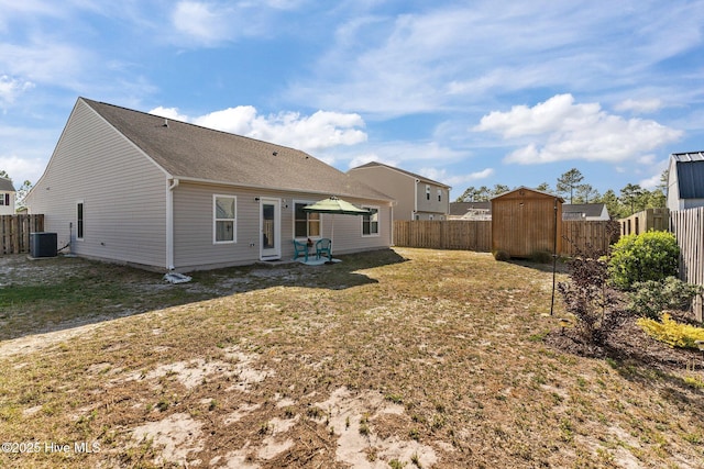 back of property with central AC, an outbuilding, a shed, and a fenced backyard