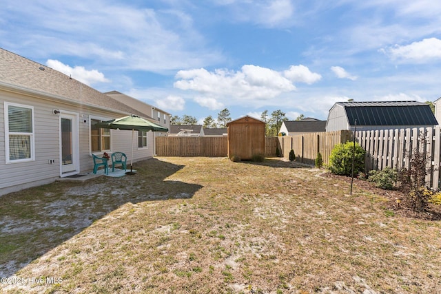 view of yard featuring a fenced backyard, an outbuilding, and a shed