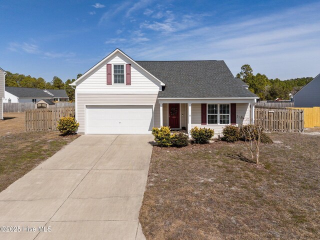 traditional-style house featuring concrete driveway, fence, covered porch, and a garage
