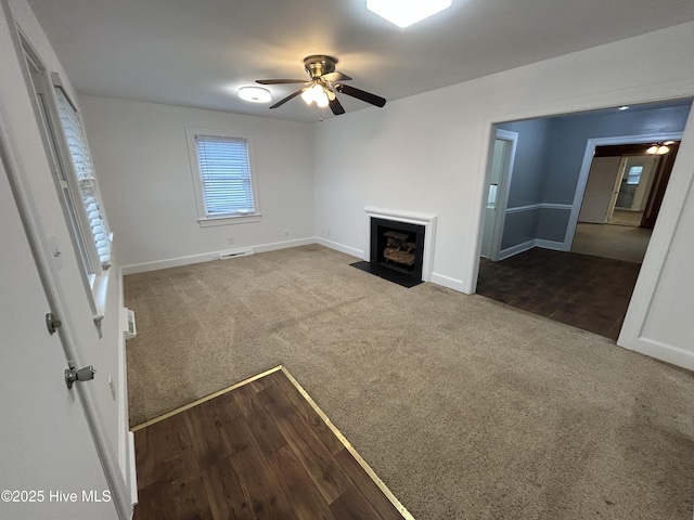 unfurnished living room featuring carpet flooring and ceiling fan