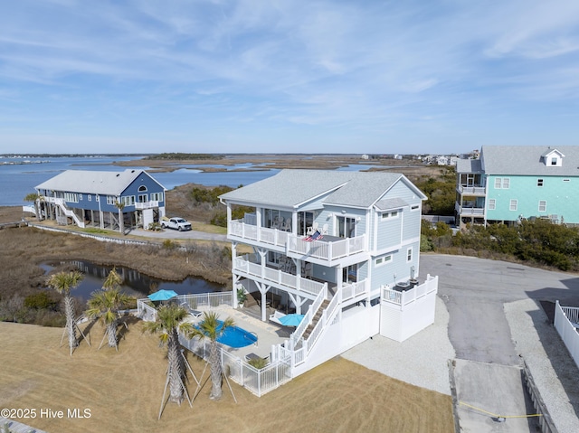 rear view of property featuring a water view and a balcony