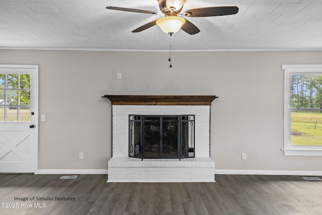 unfurnished living room with a brick fireplace, ceiling fan, crown molding, and dark hardwood / wood-style floors