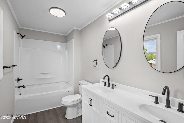 full bathroom featuring wood-type flooring, vanity, crown molding, toilet, and  shower combination