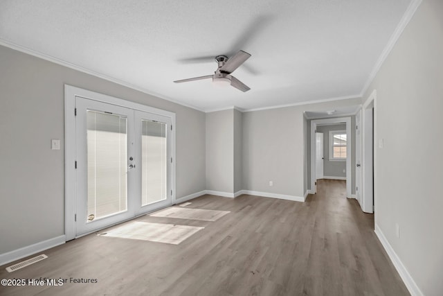 spare room featuring ornamental molding, french doors, ceiling fan, and light hardwood / wood-style flooring