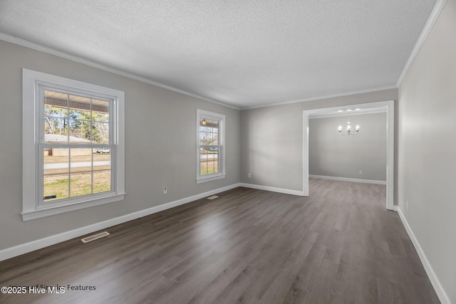 empty room featuring a textured ceiling, ornamental molding, an inviting chandelier, and dark hardwood / wood-style flooring